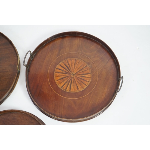 20 - Three George III and later circular mahogany gallery trays, each with brass loop handles, largest di... 