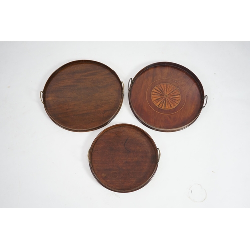 20 - Three George III and later circular mahogany gallery trays, each with brass loop handles, largest di... 