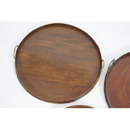 20 - Three George III and later circular mahogany gallery trays, each with brass loop handles, largest di... 