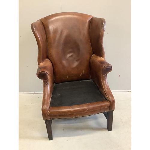 1046 - A George III style oak and tan leather wing back armchair, width 76cm, depth 70cm, height 112cm. Con... 