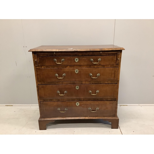 1062 - A mid 18th century feather banded walnut chest, fitted four long drawers, beneath a brushing slide, ... 