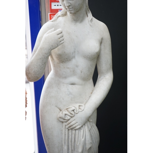 1120 - After the Antique. A large carved reconstituted marble figure of Venus, standing beside a tree trunk... 