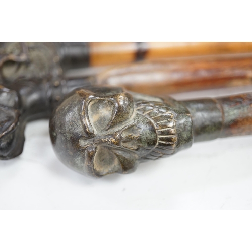 1320 - Four bronze topped walking canes, two with skulls, and two with dogs, canvas longest 93cm. Condition... 