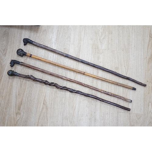 1320 - Four bronze topped walking canes, two with skulls, and two with dogs, canvas longest 93cm. Condition... 