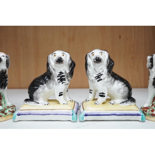 1359 - A pair of mid 19th century Staffordshire spaniels seated on cushions and a pair of similar groups of... 