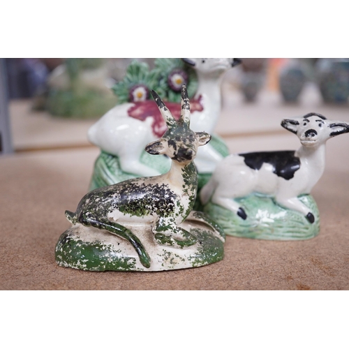 1384 - Two late 18th century Staffordshire coloured creamware figures of recumbent cows and a spongeware de... 