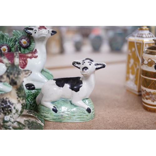 1384 - Two late 18th century Staffordshire coloured creamware figures of recumbent cows and a spongeware de... 