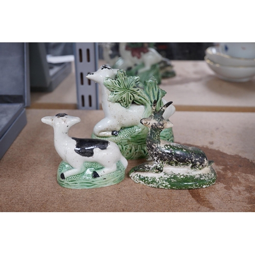 1384 - Two late 18th century Staffordshire coloured creamware figures of recumbent cows and a spongeware de... 