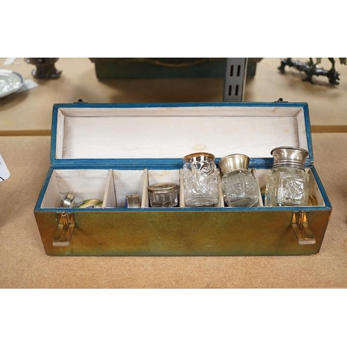 1395 - A green leather sectioned box containing a collection of cut glass, silver mounted and silver plated... 