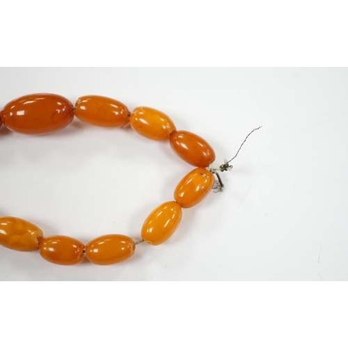 1900 - A single strand graduated amber bead necklace, 66cm, gross weight 40 grams. Condition - poor to fair... 