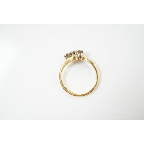 1909 - A modern `18ct gold and three stone diamond set crossover ring, size O, gross weight 3.4 grams. Cond... 