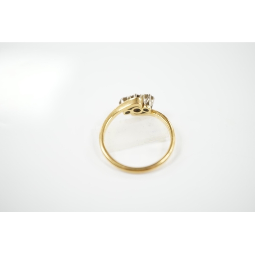 1909 - A modern `18ct gold and three stone diamond set crossover ring, size O, gross weight 3.4 grams. Cond... 