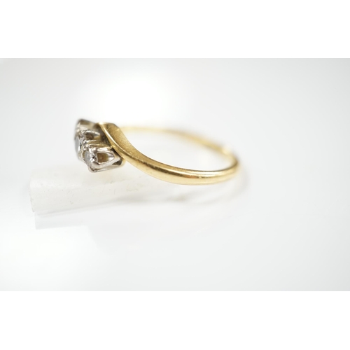 1909 - A modern `18ct gold and three stone diamond set crossover ring, size O, gross weight 3.4 grams. Cond... 