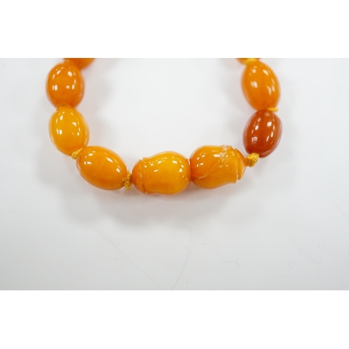 1918 - A single strand graduated oval amber bead necklace, 66cm, gross weight 48 grams. Condition - poor to... 