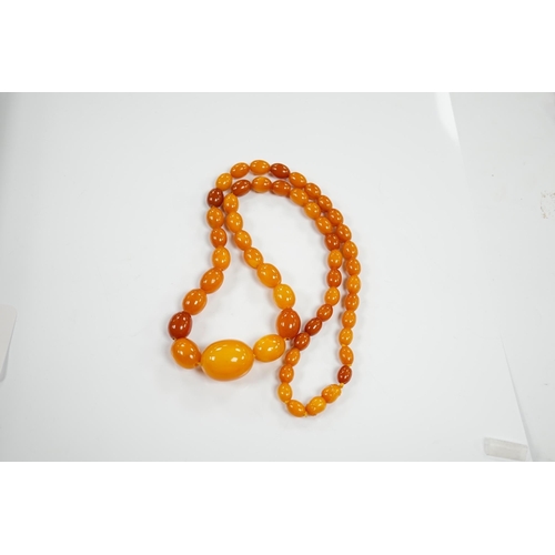 1918 - A single strand graduated oval amber bead necklace, 66cm, gross weight 48 grams. Condition - poor to... 