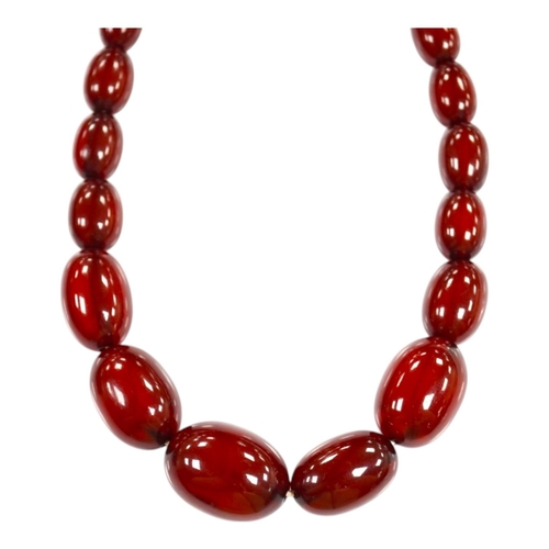 1919 - A single strand graduated oval simulated cherry amber bead necklace, 38cm, gross weight 41 grams. Co... 