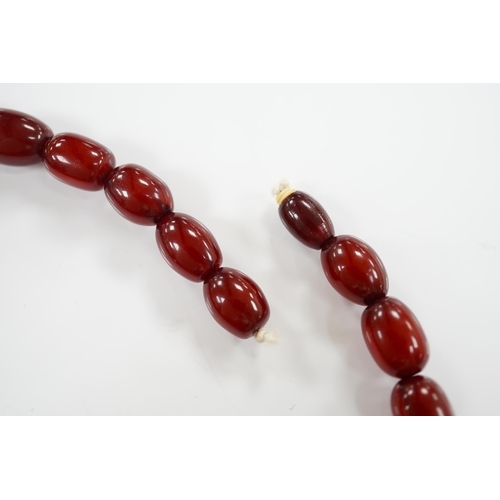 1919 - A single strand graduated oval simulated cherry amber bead necklace, 38cm, gross weight 41 grams. Co... 