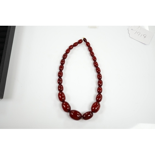 1919 - A single strand graduated oval simulated cherry amber bead necklace, 38cm, gross weight 41 grams. Co... 