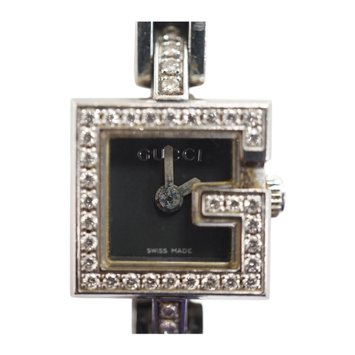 1928 - A lady's stainless steel Gucci quartz wrist watch, with G shaped case and diamond chip set bezel, on... 