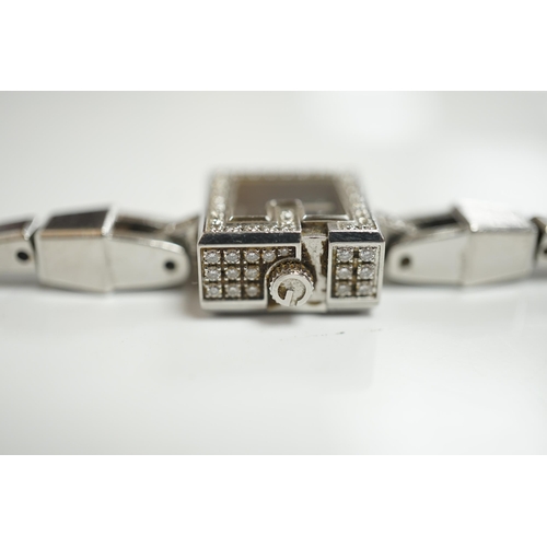 1928 - A lady's stainless steel Gucci quartz wrist watch, with G shaped case and diamond chip set bezel, on... 