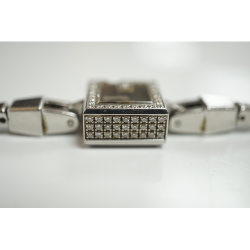 1928 - A lady's stainless steel Gucci quartz wrist watch, with G shaped case and diamond chip set bezel, on... 