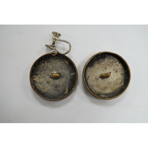 1937 - A pair of engraved gilt metal enamel and paste set disc shaped buttons )converted to earrings, one f... 