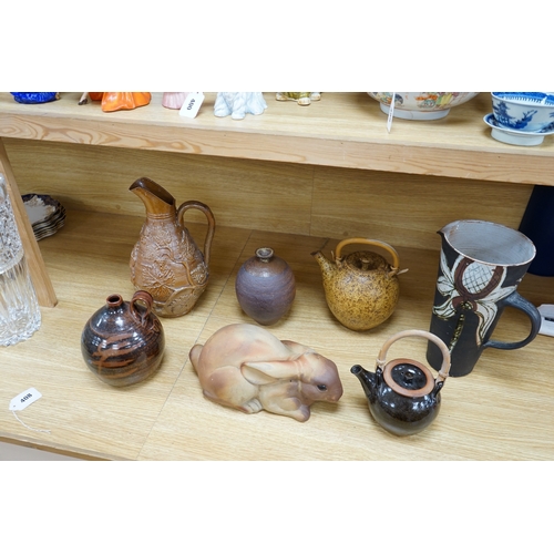 408 - A collection of Studio pottery to include teapots and jugs, together with a pottery model of a rabbi... 