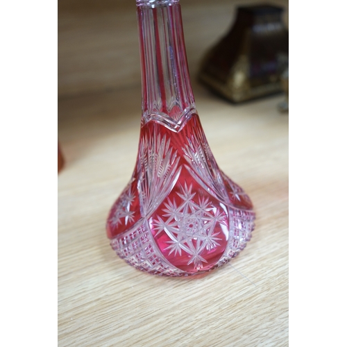 409 - A collection of cranberry glassware comprising three decanters with stoppers and a silver plate moun... 