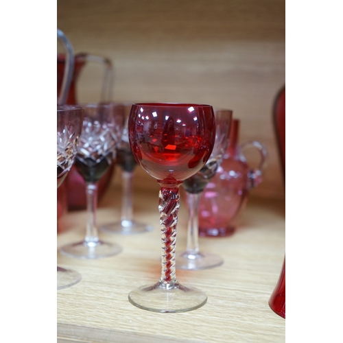 424 - Mixed cranberry glassware to include jugs, glasses, jars and a comport, largest 23cm high. Condition... 