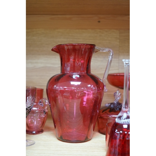 424 - Mixed cranberry glassware to include jugs, glasses, jars and a comport, largest 23cm high. Condition... 