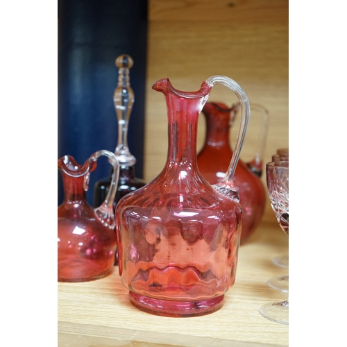 424 - Mixed cranberry glassware to include jugs, glasses, jars and a comport, largest 23cm high. Condition... 