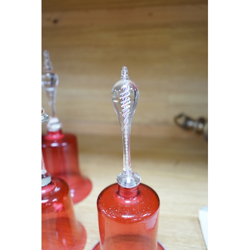 435 - Seven 19th century cranberry glass hand bells, various sizes, largest 30.5cm high. Condition - fair... 