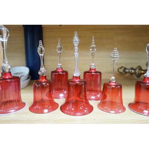 435 - Seven 19th century cranberry glass hand bells, various sizes, largest 30.5cm high. Condition - fair... 