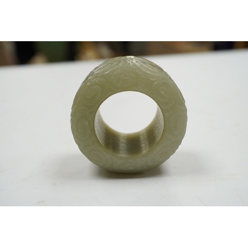 495 - A Chinese celadon jade 'cloud' thumb ring, 4cm diameter. Condition - good