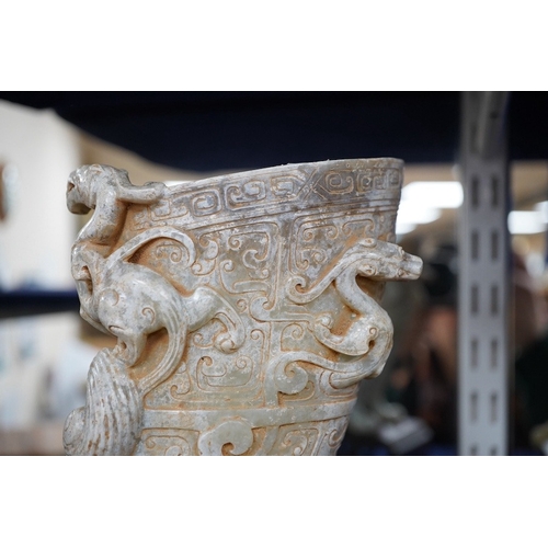 504 - A large Chinese archaistic pale celadon and calcified jade rhyton, on a hardwood stand, 17.5cm high.... 