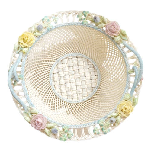 517 - A boxed Belleek coloured basket, 28cm diameter. Condition - fair to good, some damage and wear to th... 