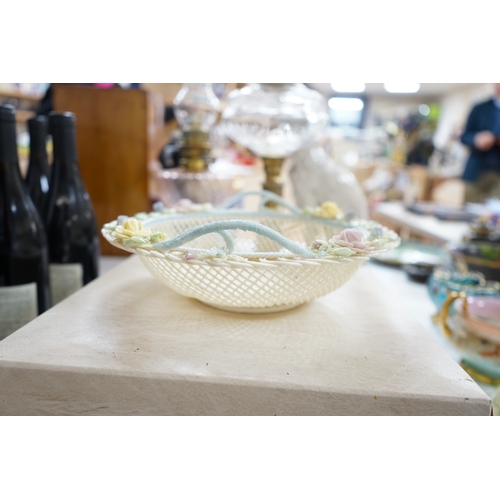 517 - A boxed Belleek coloured basket, 28cm diameter. Condition - fair to good, some damage and wear to th... 