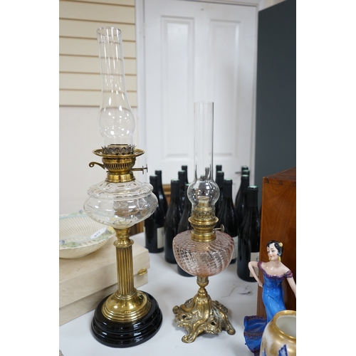 519 - Two brass oil lamps with glass spirit tanks, tallest 67cm. Condition - good.