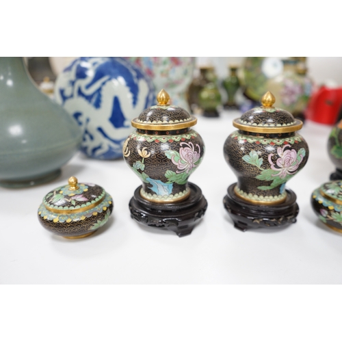 523 - A collection of Chinese cloisonné enamel vessels, some with stands, all worked on a black background... 