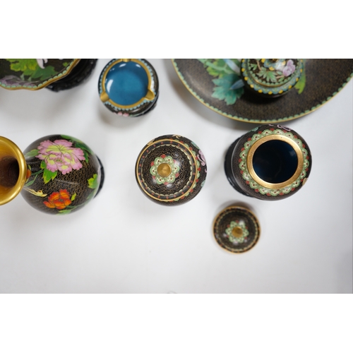 523 - A collection of Chinese cloisonné enamel vessels, some with stands, all worked on a black background... 