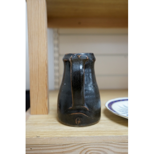 527 - Leach standard ware, a small Stoneware black glazed studio pottery jug, impressed mark to top of foo... 