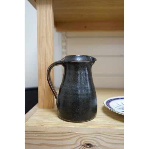 527 - Leach standard ware, a small Stoneware black glazed studio pottery jug, impressed mark to top of foo... 