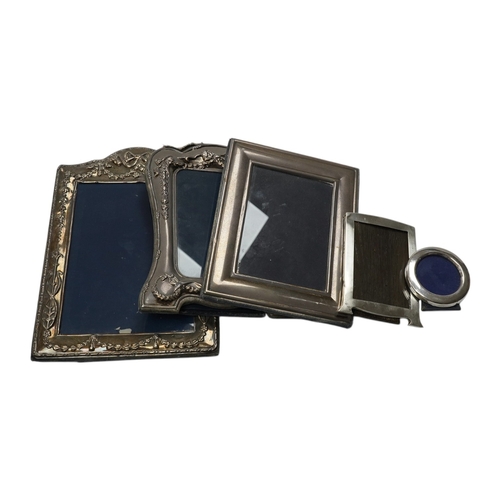 831 - A small George V silver mounted photograph frame, 11.2cm, together with three larger modern silver m... 