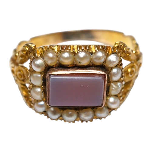 917 - A Victorian yellow metal, carnelian and split pearl set ring, with carved split shoulders, size L, g... 