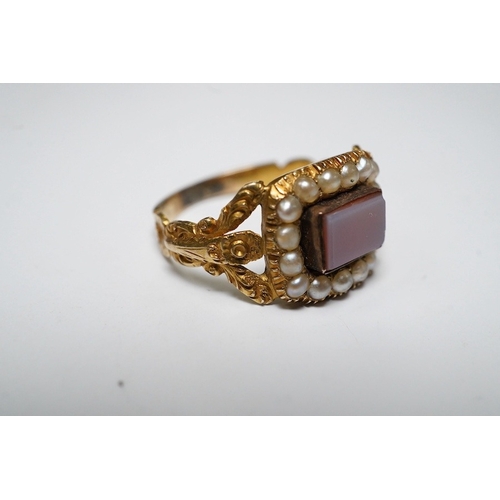 917 - A Victorian yellow metal, carnelian and split pearl set ring, with carved split shoulders, size L, g... 