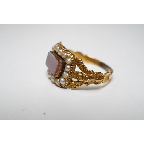 917 - A Victorian yellow metal, carnelian and split pearl set ring, with carved split shoulders, size L, g... 