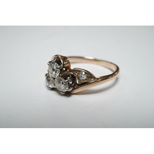 929 - A yellow metal and three stone diamond set crossover ring, with single stone diamond set shoulder, s... 