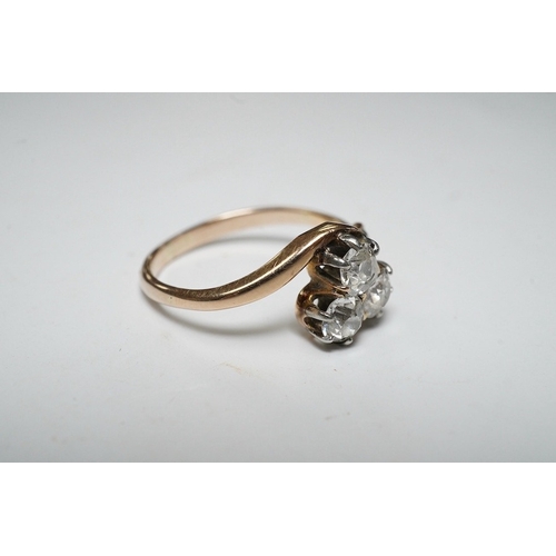 929 - A yellow metal and three stone diamond set crossover ring, with single stone diamond set shoulder, s... 