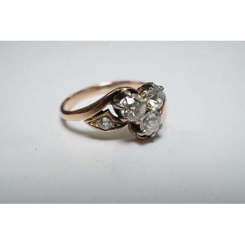 929 - A yellow metal and three stone diamond set crossover ring, with single stone diamond set shoulder, s... 