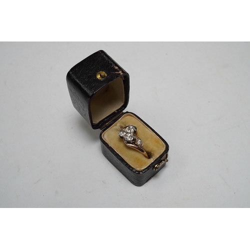 929 - A yellow metal and three stone diamond set crossover ring, with single stone diamond set shoulder, s... 